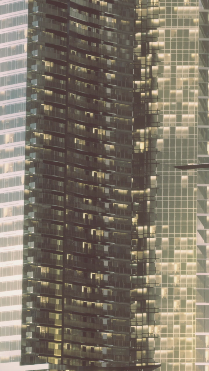 Tall buildings reflect light in urban setting with many windows at night
