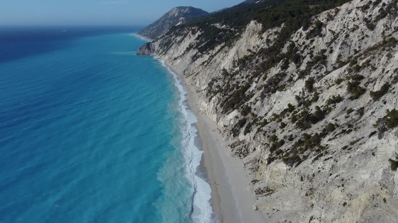 High altitude shot of the Aegean waves hitting the shore of the Egremni beach in Lefkada Greece
