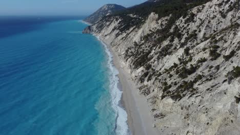 High-altitude-shot-of-the-Aegean-waves-hitting-the-shore-of-the-Egremni-beach-in-Lefkada-Greece