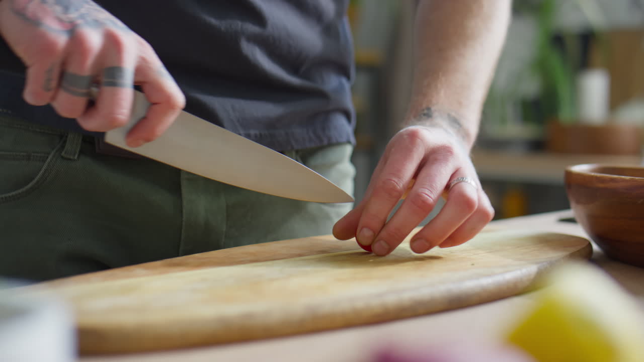 Hands of Chef Cutting Cherry Tomatoes