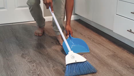 man is cleaning the house with a broom stick, domestic household maintenance concept