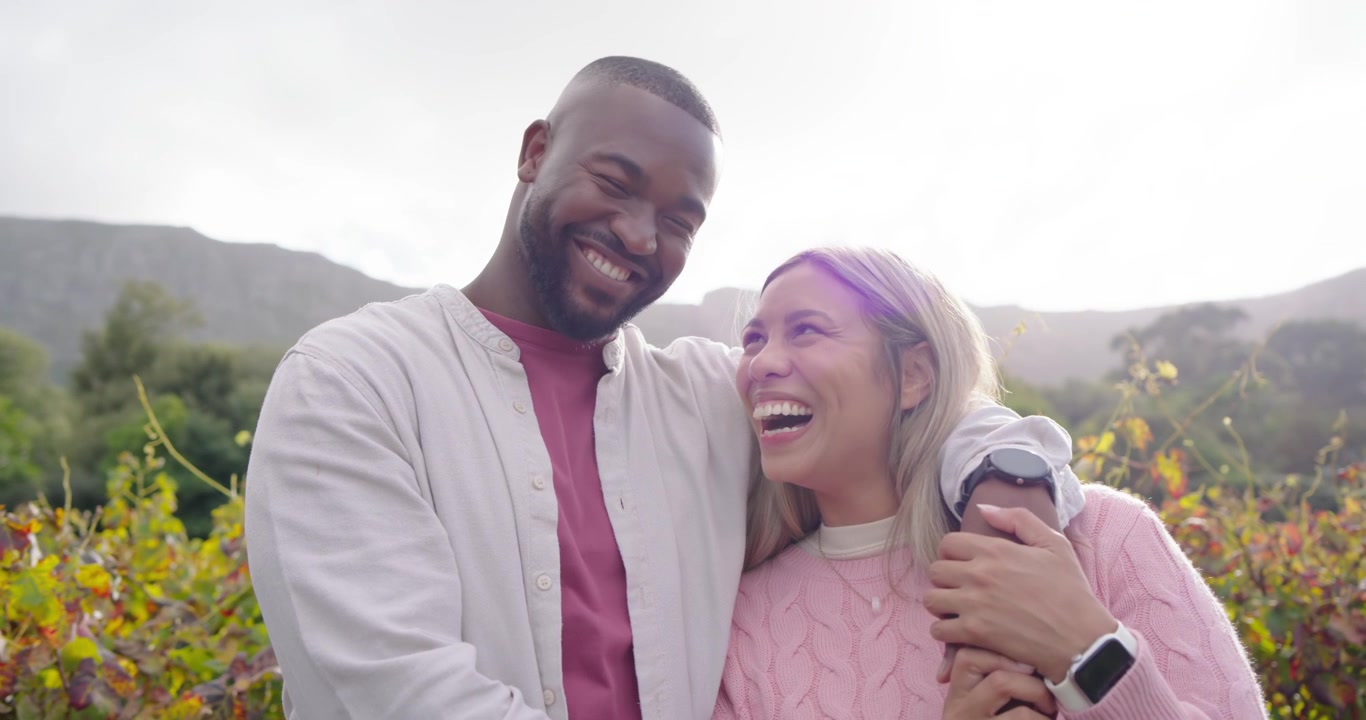 African American couple sharing affection as man draping arm on shoulder, smartwatch in vineyard