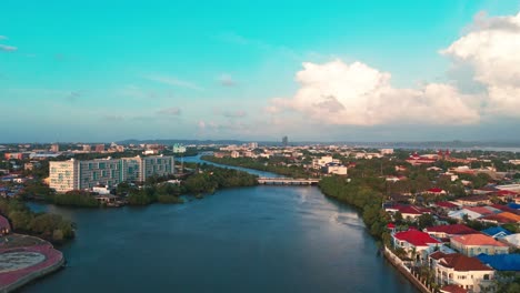 aerial of a riverside city in the philippines with bridges, coastal road, and urban skyline under a bright blue sky. perfect for travel, urban, and landscape projects