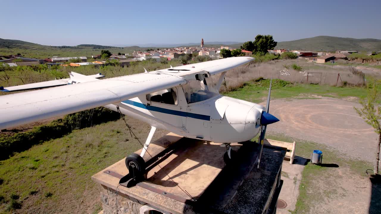 drone lento de 4k revelando el pequeño pueblo rural de alcublas con un viejo cessna 172 como exposición, españa
