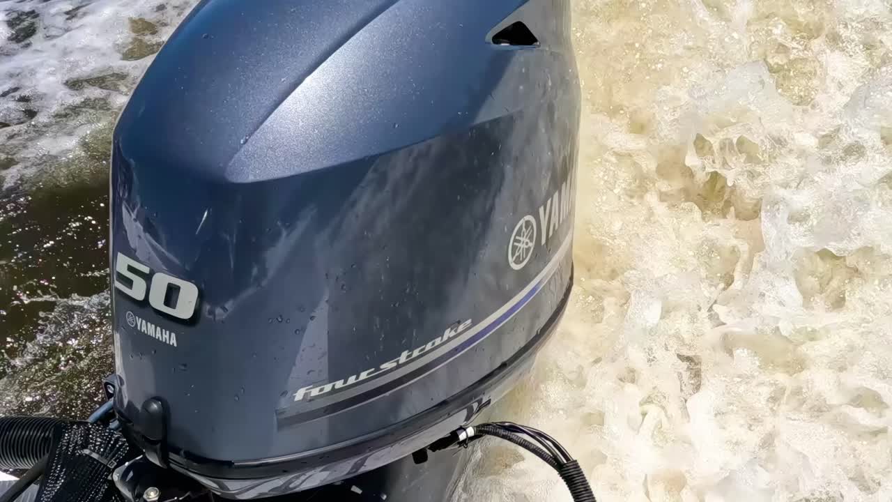 Close-up view of a Yamaha 50 horsepower outboard motor navigating through turbulent waters.