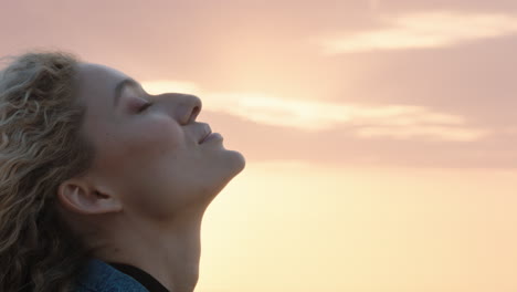 close up portrait of beautiful blonde woman enjoying peaceful seaside at sunset contemplating journey exploring spirituality feeling freedom with wind blowing hair