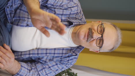 Vertical-video-of-The-old-man-making-cute-gestures-for-the-camera.