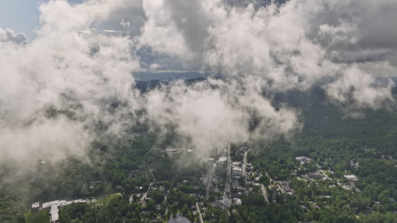 하이랜드 노스 캐롤라이나 에어리얼 v13 고고도 드론이 안개 구름을 통해 비행하여 산악 풍경에서 푸른 숲으로 둘러싸인 마을 중심을 드러 ⁇ 니다 - mavic 3 영화로 촬영 - 2022 년 7 월