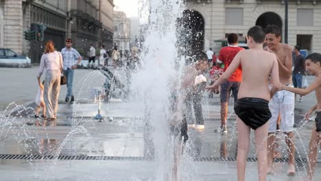 kids, refreshing in a fountain through the streets of turin to take off the heat wave.