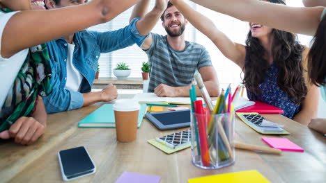 video of creative diverse male and female colleagues high fiving in modern office