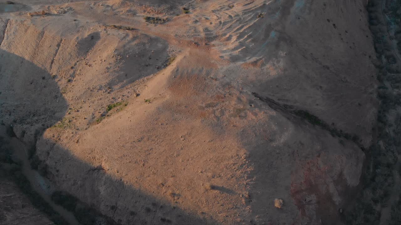 tiro de dron de un desierto monta, camino rizado, aspecto de parque jurásico, cielo azul