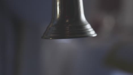 close up of alter bell repeatedly ringing during mass in historic church