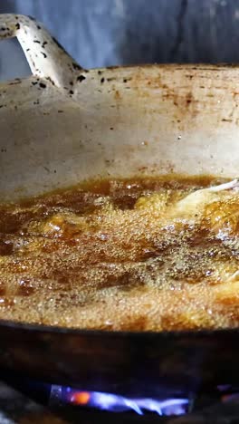 cocinar carne en una sartén sobre una llama abierta