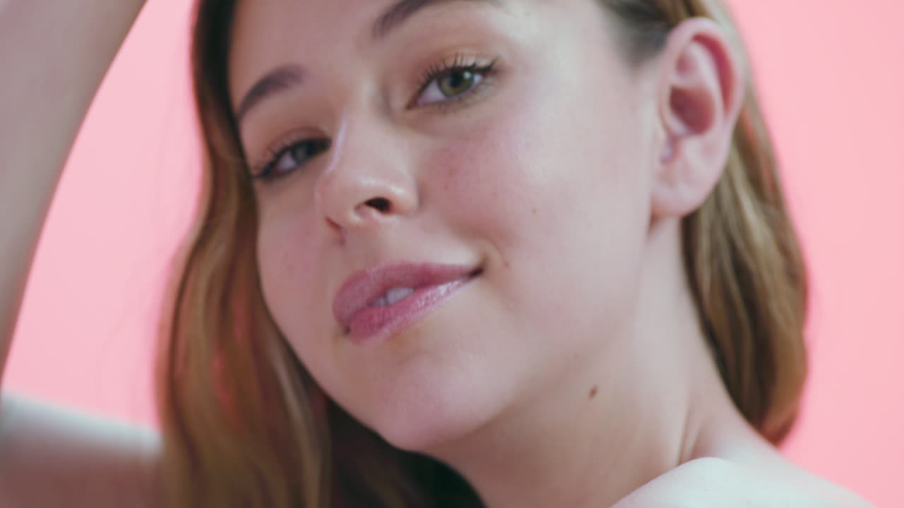 una hermosa mujer joven posando contra un rosa