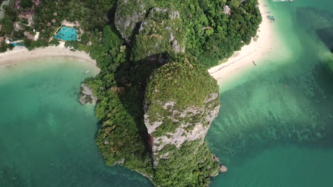 birds eye aerial view of breathtaking exotic white sand beach lagoon and green cliffs over tropical sea