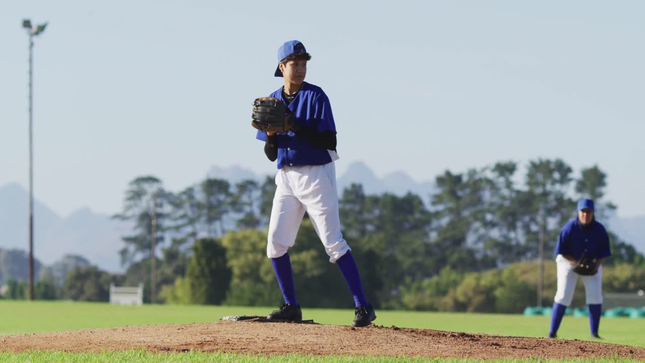 Giocatrice di baseball caucasica con gli occhiali che lancia la palla su un campo da baseball.