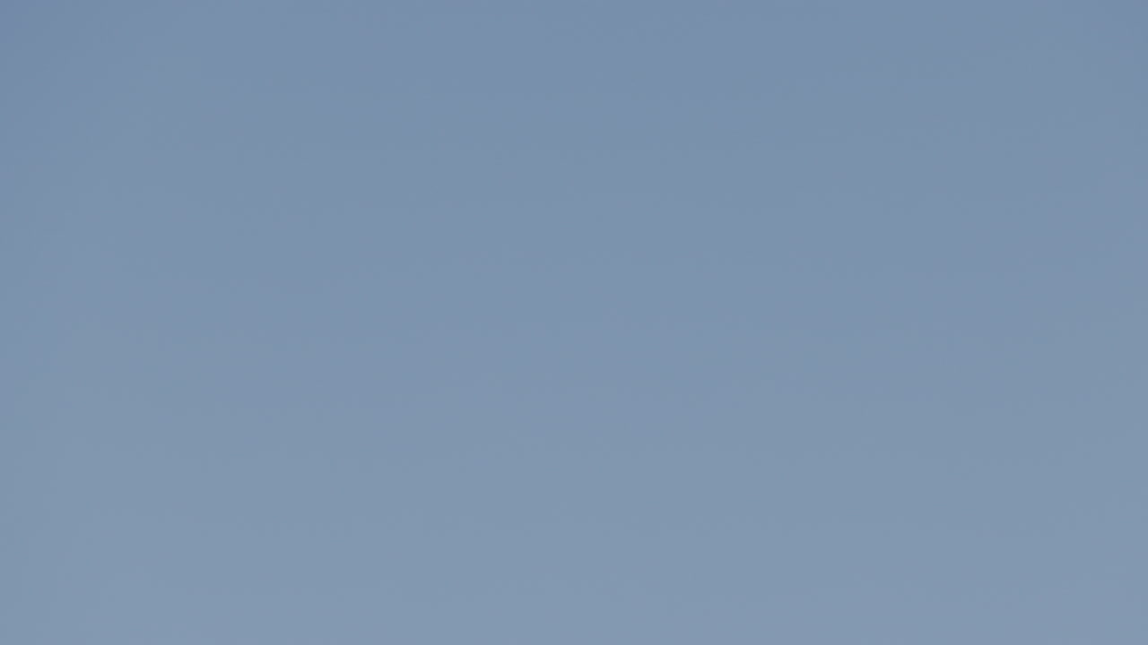 공항에 착륙하기 위해 석양 아래에서 매우 느린 속도로 머리 위를 날아가는 비행기