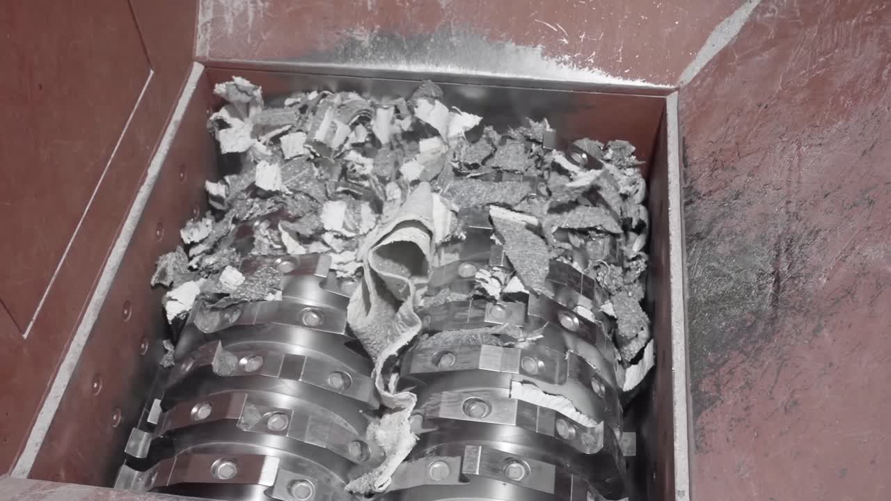 Industrial Shredder Machine, tearing and shredding material, close-up view, metal blades, processing waste. Powerful destruction of materials.