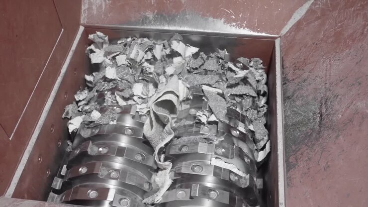 Industrial Shredder Machine, tearing and shredding material, close-up view, metal blades, processing waste. Powerful destruction of materials.