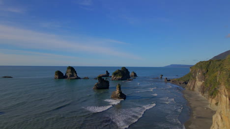 rocky pillars on wild sea shore in tasman sea near new zealand