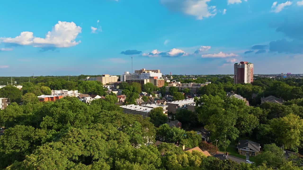 Residential neighbourhood and buildings surrounded by lush greenery, trees under clear blue sky, Atlanta, Georgia, Aerial view