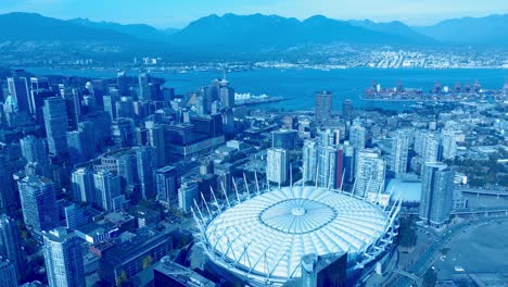 bc place stadium cfl birds top view overlooking the downtown peninsula plaza of nations next to stanley park north vancouver harbor with mountains and the commercial freighter port of east hastings