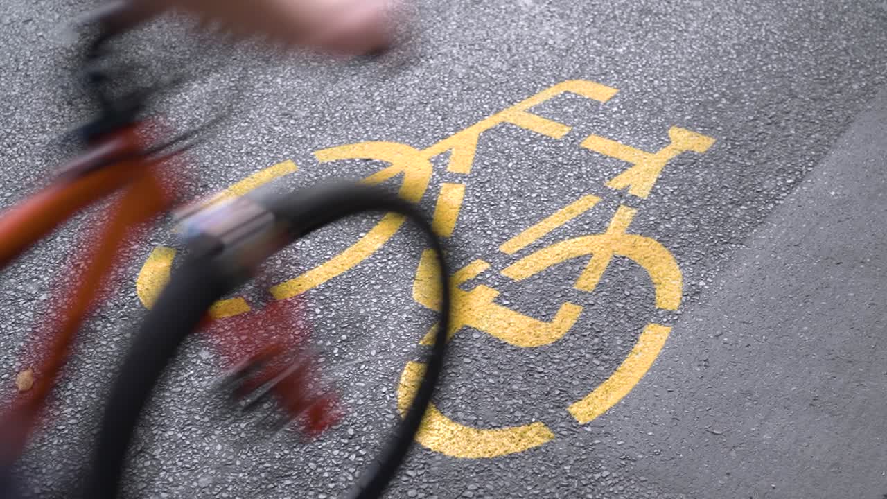 Bicycle lane marking on asphalt with a cyclist passing by