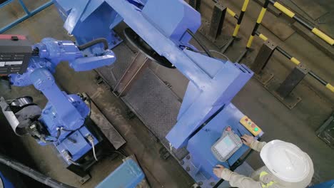 sparks and smoke from a robot welding in metallurgy plant. top-down