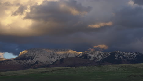 dense cloudscape rolling over slope mountains at sunset