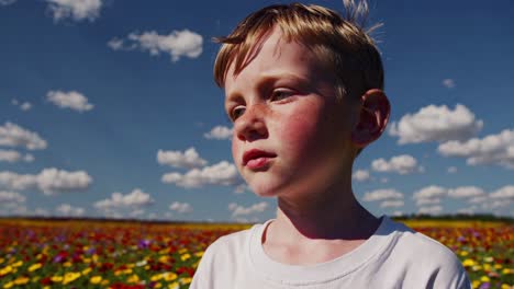 portrait of a young boy with sun kissed skin, enjoying a summer day under a vibrant blue sky filled with fluffy clouds, capturing the joy of carefree childhood