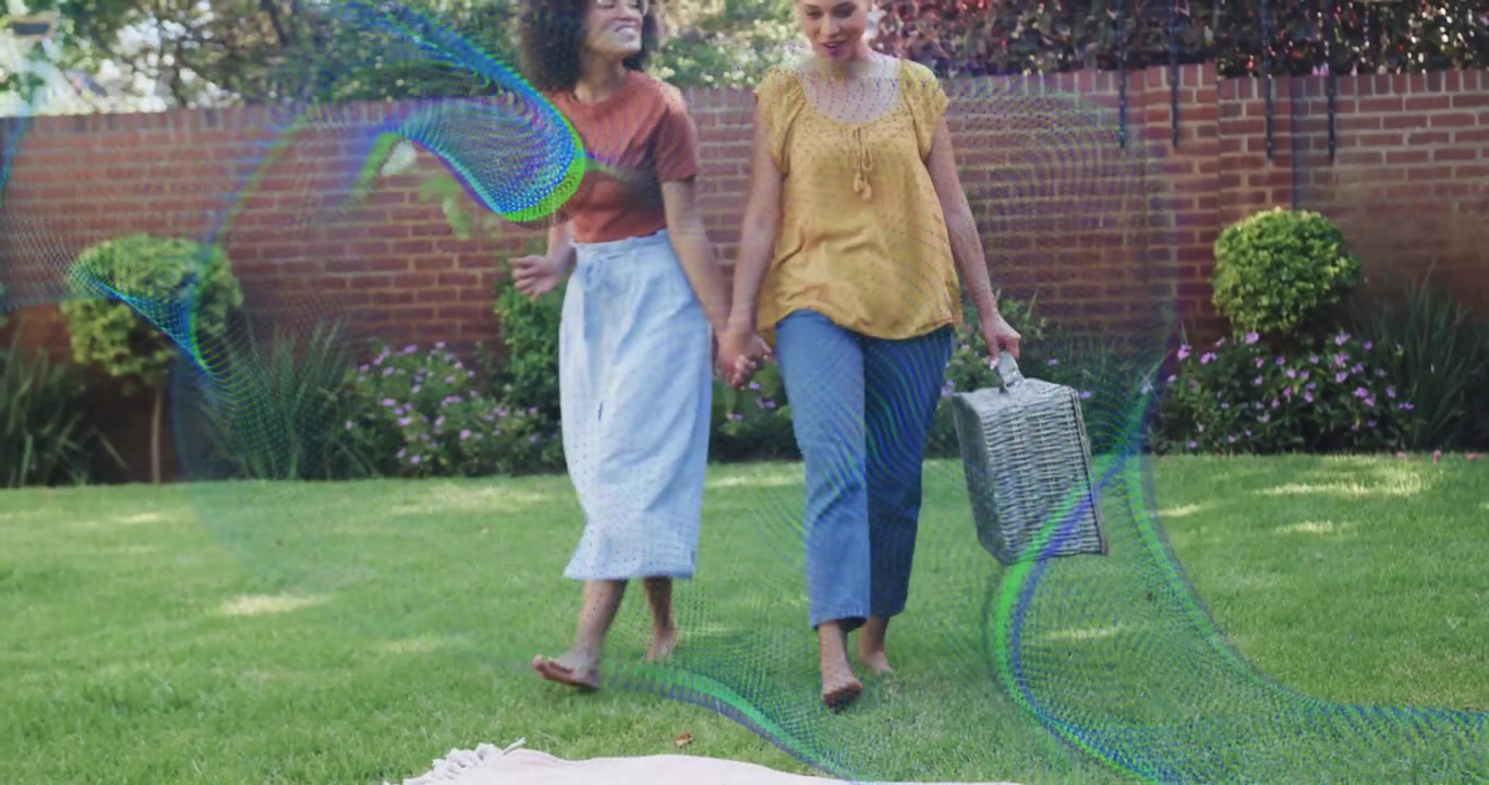 Two women walking carrying basket initiating swirling tech effect on blanket preparing gathering