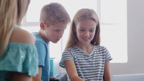 two students building and programing robot vehicle in after school computer coding class