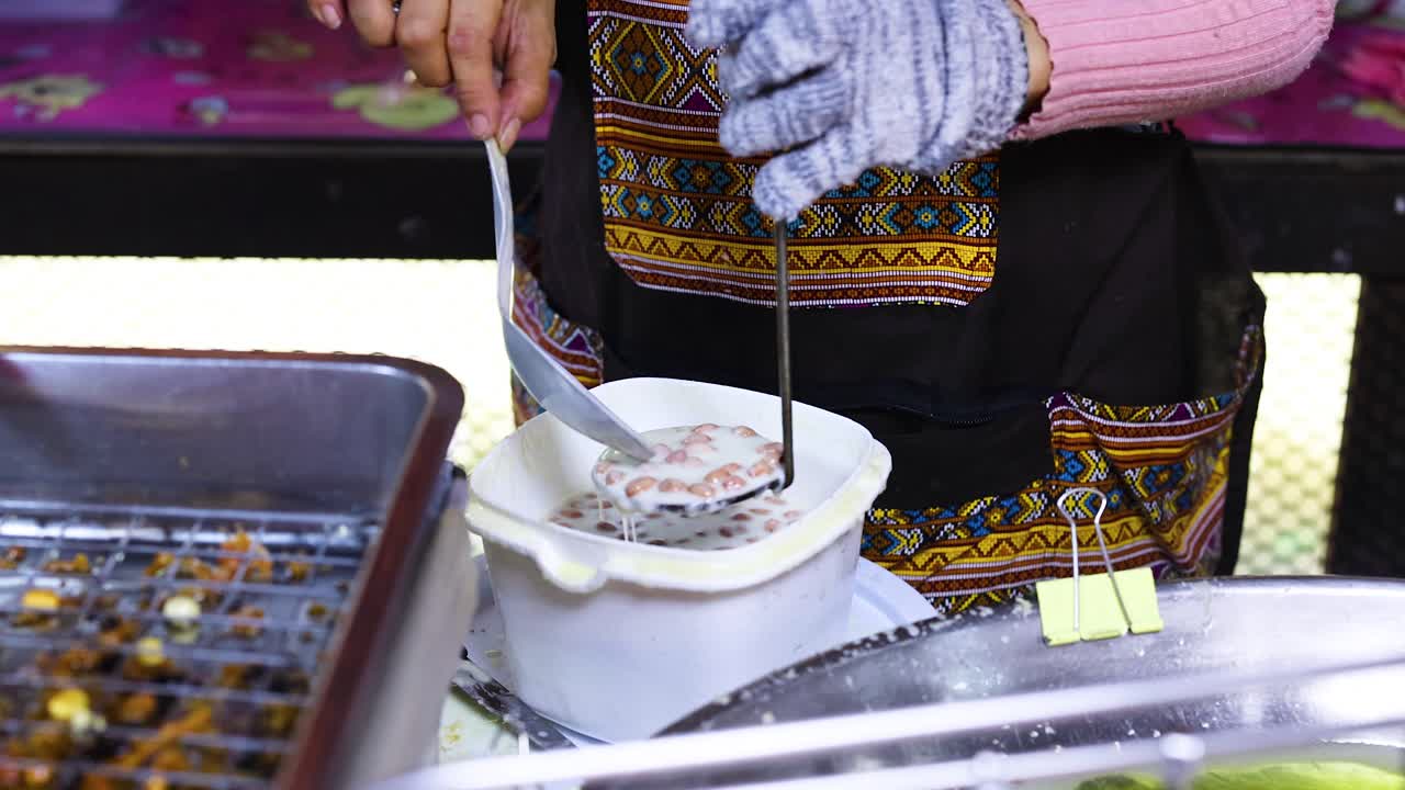 판매자는 방 시장에서 전통적인 쿠키를 준비합니다.