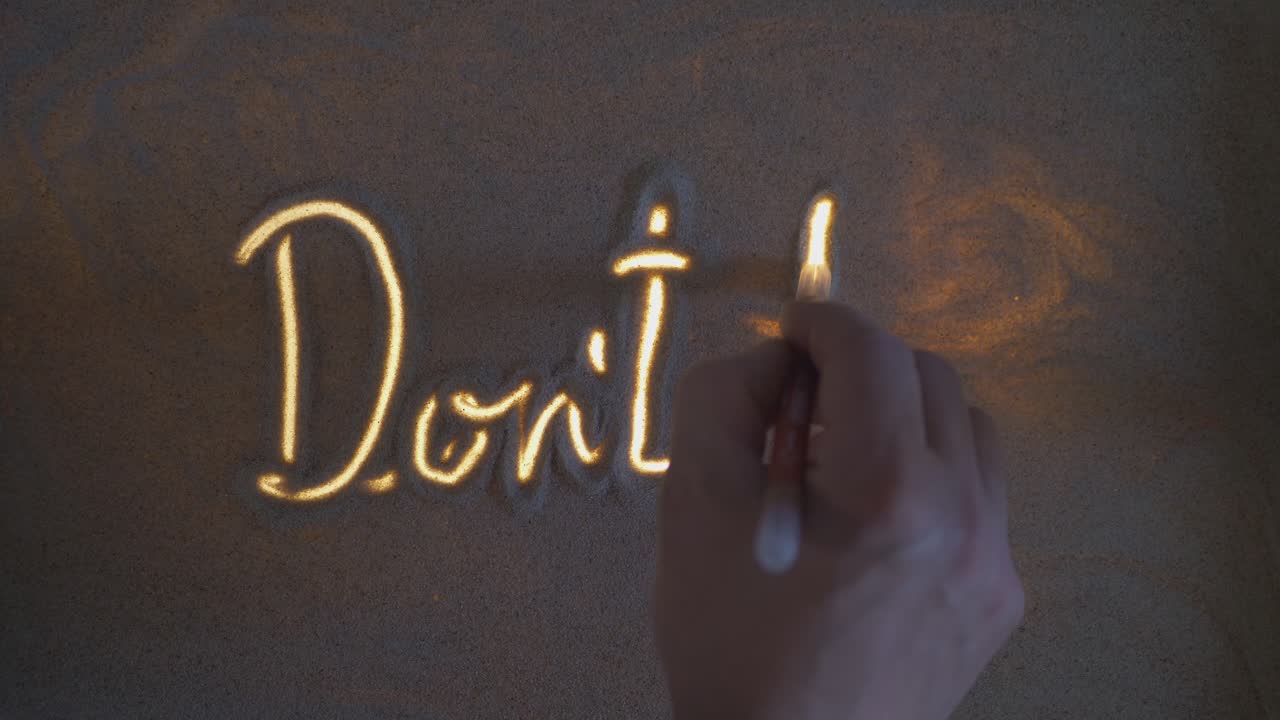 Iscrizione su una riga con la scritta "Don’t Panic". Sabbia su vetro illuminato