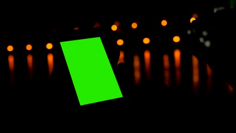 mujer usando un teléfono inteligente con pantalla verde en la cubierta de un crucero por la noche