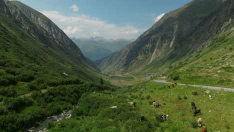 antena volando más allá del edificio al lado de la carretera junto a la sinuosa carretera del valle hacia el valle del paso de grimsel en los alpes en suiza