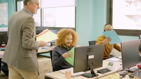manager distributes files to a team in coworking space