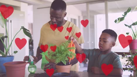 Animation-of-hearts-over-happy-african-american-father-and-son-gardening