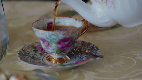 Close-Up-of-a-Floral-Tea-Cup-as-Fresh-Tea-is-Being-Poured