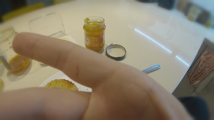 POV first person eating bread with jam for breakfast in modern kitchen