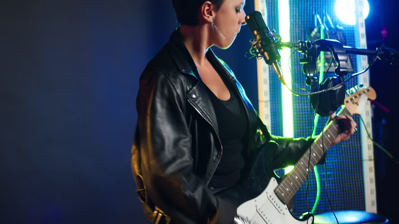 Woman singing and playing guitar in studio