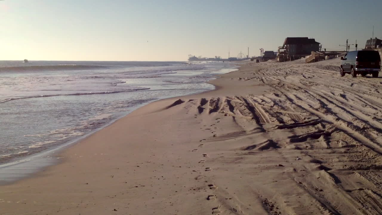 아름다운 늦여름날 저지 해안의 고요한 빈 해변에서 잔잔한 파도가 부서진다