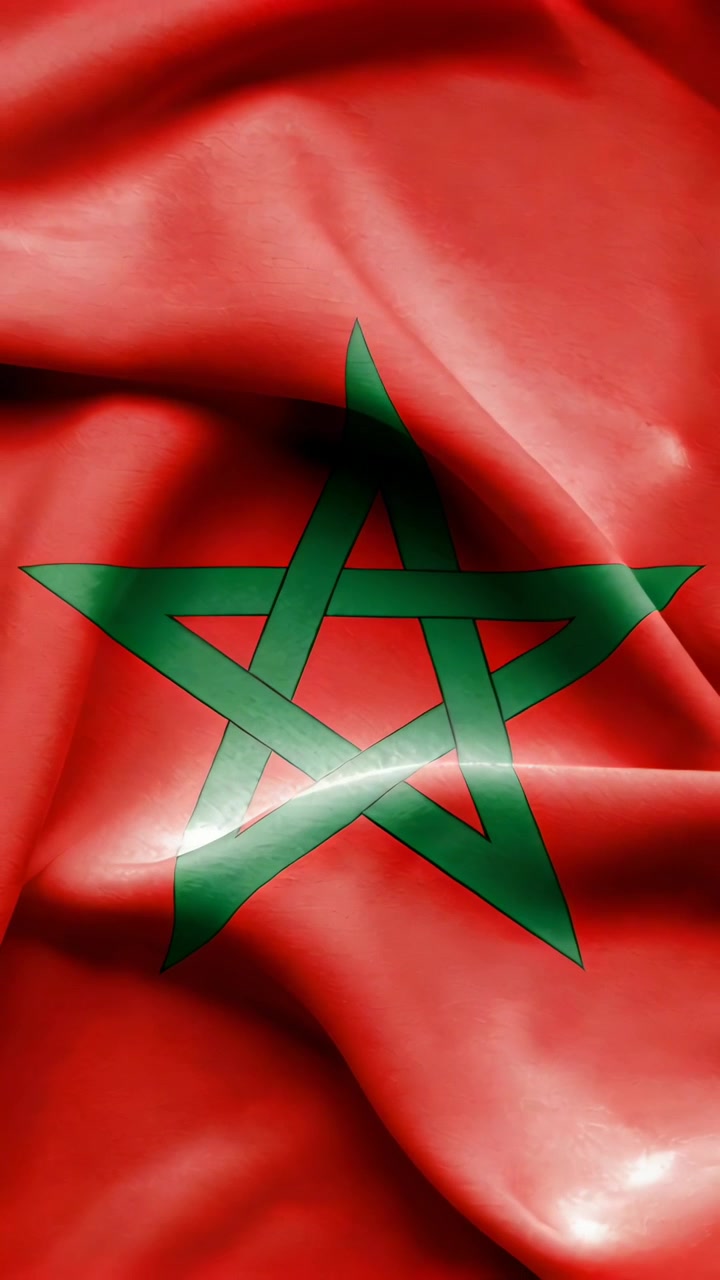 Video verticale: Tessuto increspato della bandiera marocchina che sventola in primo piano per la brezza, con una stella verde che brilla.