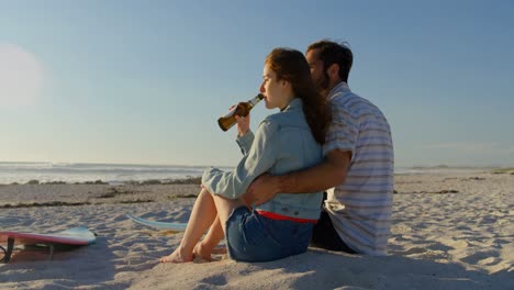 Couple-having-beer-at-beach-on-a-sunny-day-4k