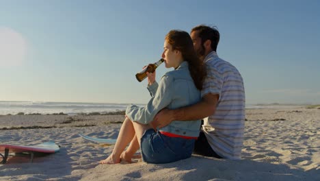 couple having beer at beach on a sunny day 4k
