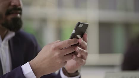 cropped shot of businessman messaging by smartphone