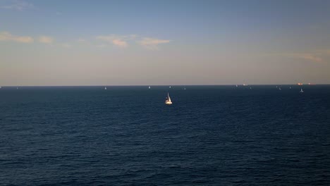 enjoy the mediterranean charm of barcelona with its calm blue waters, sailing boats on the horizon, and clear skies. perfect for coastal adventures and relaxation.