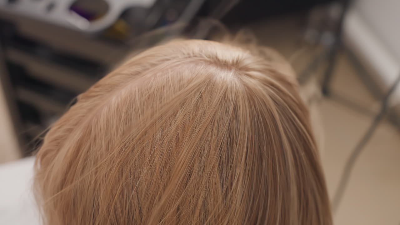 Donna bionda caucasica, parrucchiere cotonatura, sequenza, stilista che cotona i capelli alle radici per dare volume ed elasticità, cipria e pennello usati per creare la texture, inquadratura ravvicinata che cattura le mani ritmiche, sedia da salone