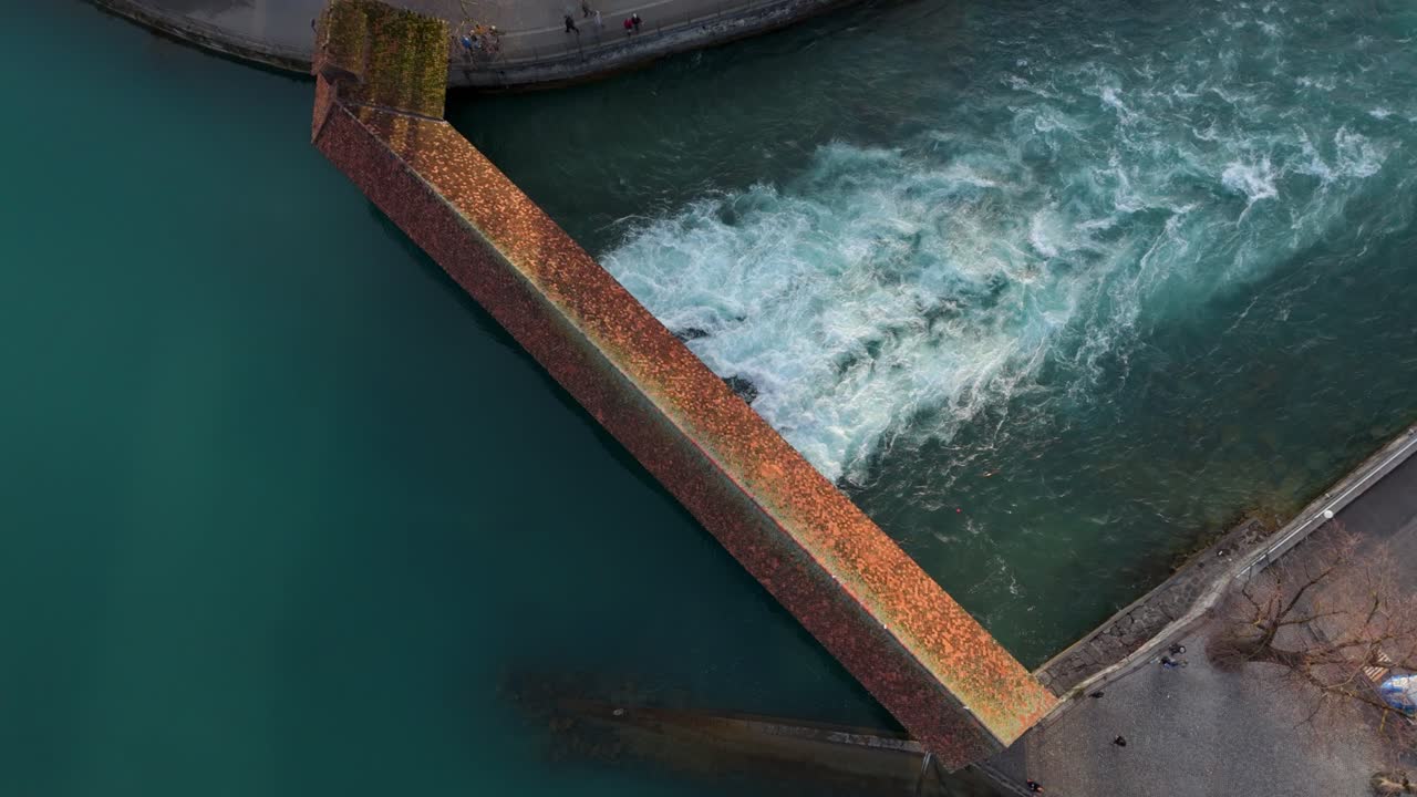 Aare river stream flowing from sluice below covered bridge, Thun town