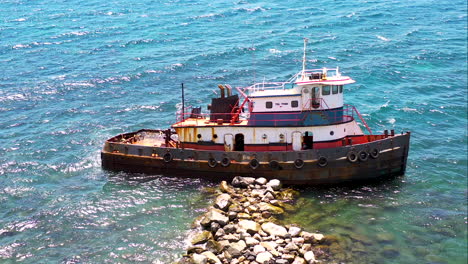 Schiffswrack-Eines-Verlassenen-Alten-Rostigen-Fischerschiffs,-Das-An-Einem-Pier-Aus-Felsen-Auf-Der-Insel-St.-Verankert-Ist